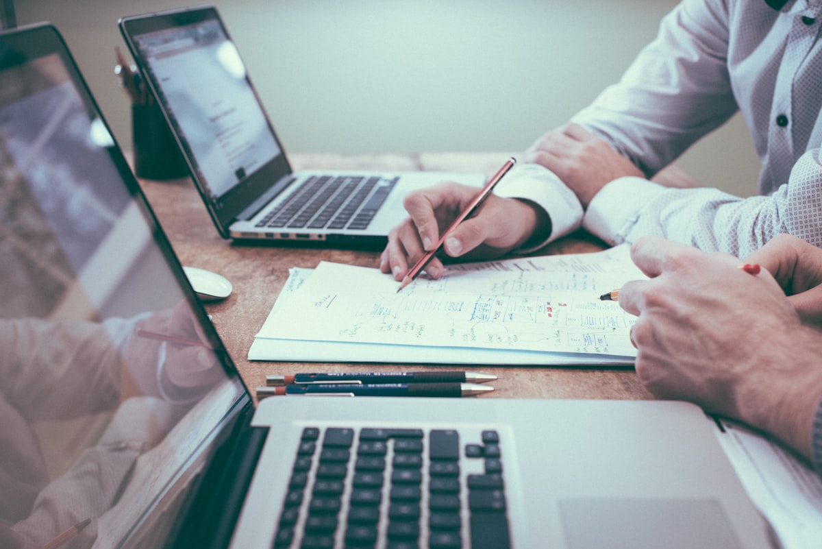 Consultores analisando documentos financeiros lado a lado